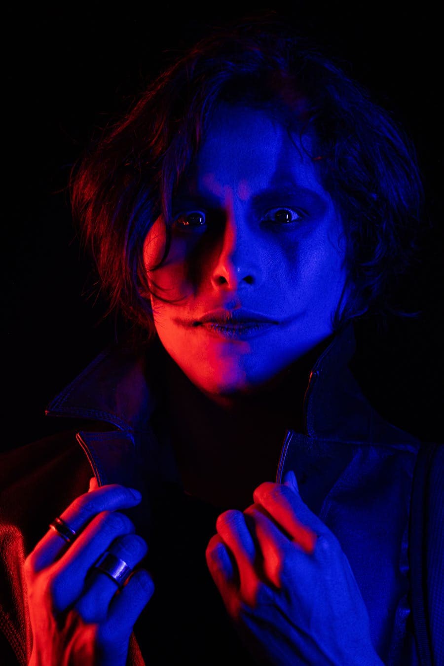 Portrait lit with red and blue neon light.